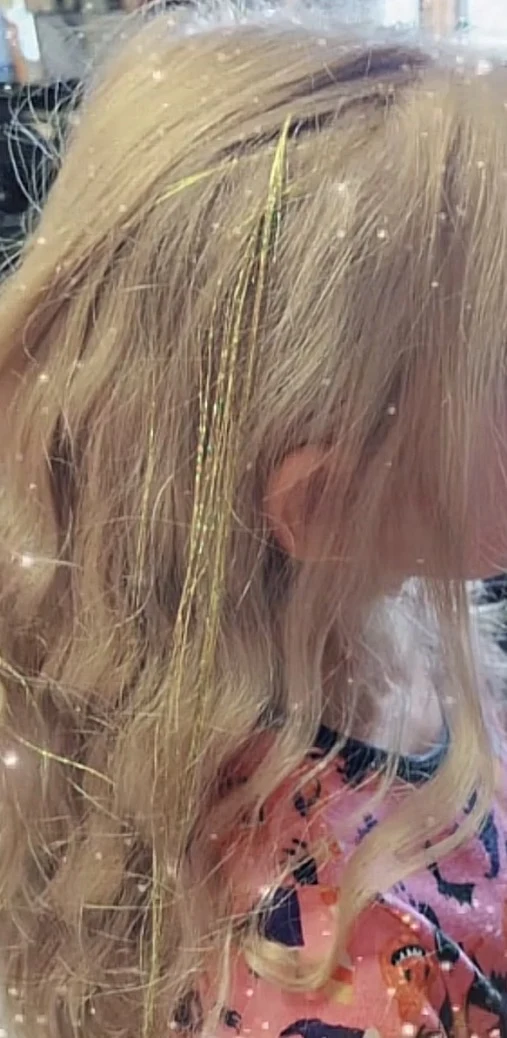 Golden tinsel sparkling in blonde curls