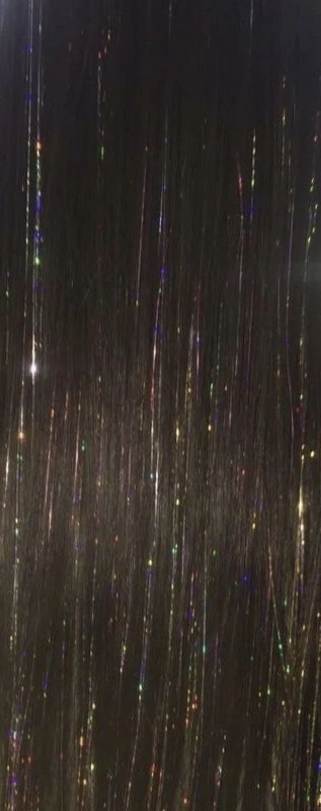 Delicate rainbow tinsel in long dark hair