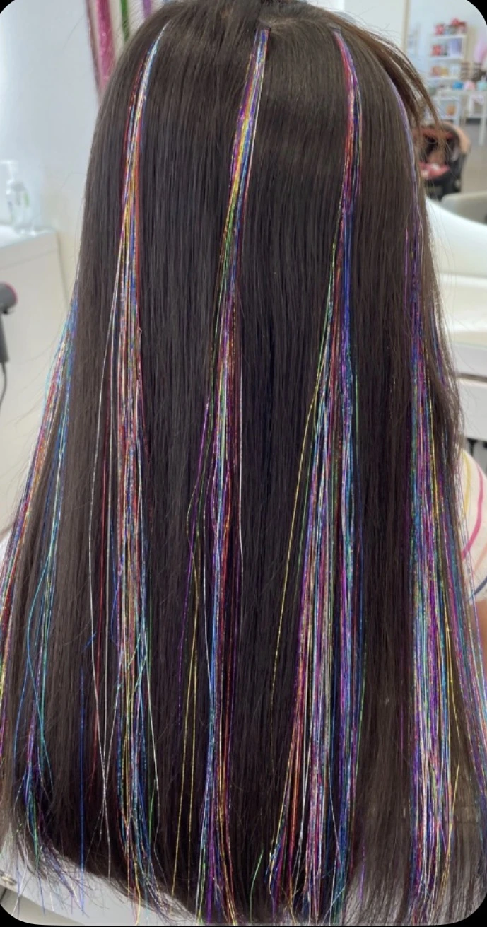 Rainbow tinsel strands through long dark hair